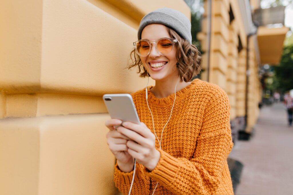 Ragazza si esercita per l'esame di teoria della patente sul suo smartphone utilizzando le App Guida e Vai: App Quiz Patente Ufficiale e App KA